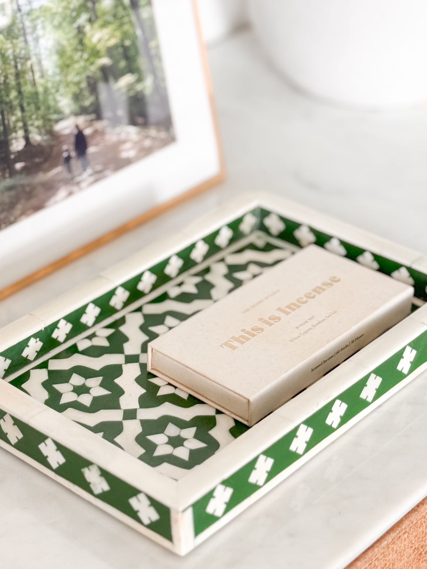 Product packaging with 'Nelly & Inez' branding on a decorative tray with green and white pattern.