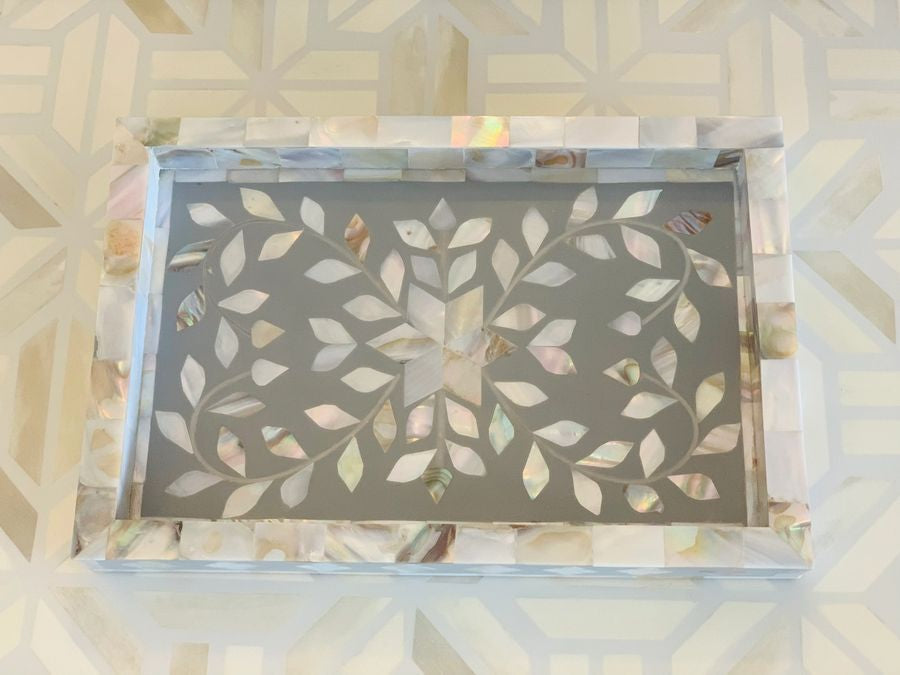 Decorative tray with leaf pattern on a textured surface