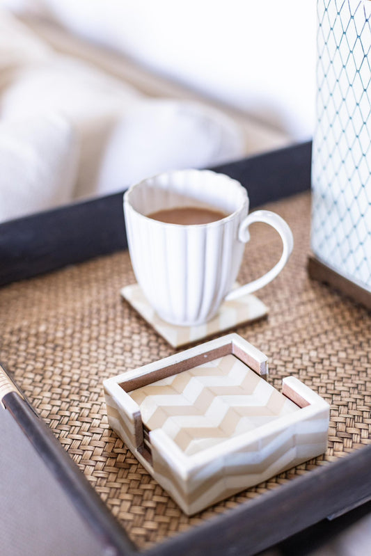 White mug with coffee on a woven tray with a box of tissues.