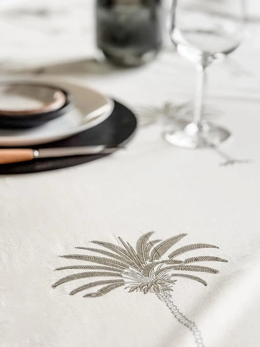 Table setting with a palm tree design on a white tablecloth