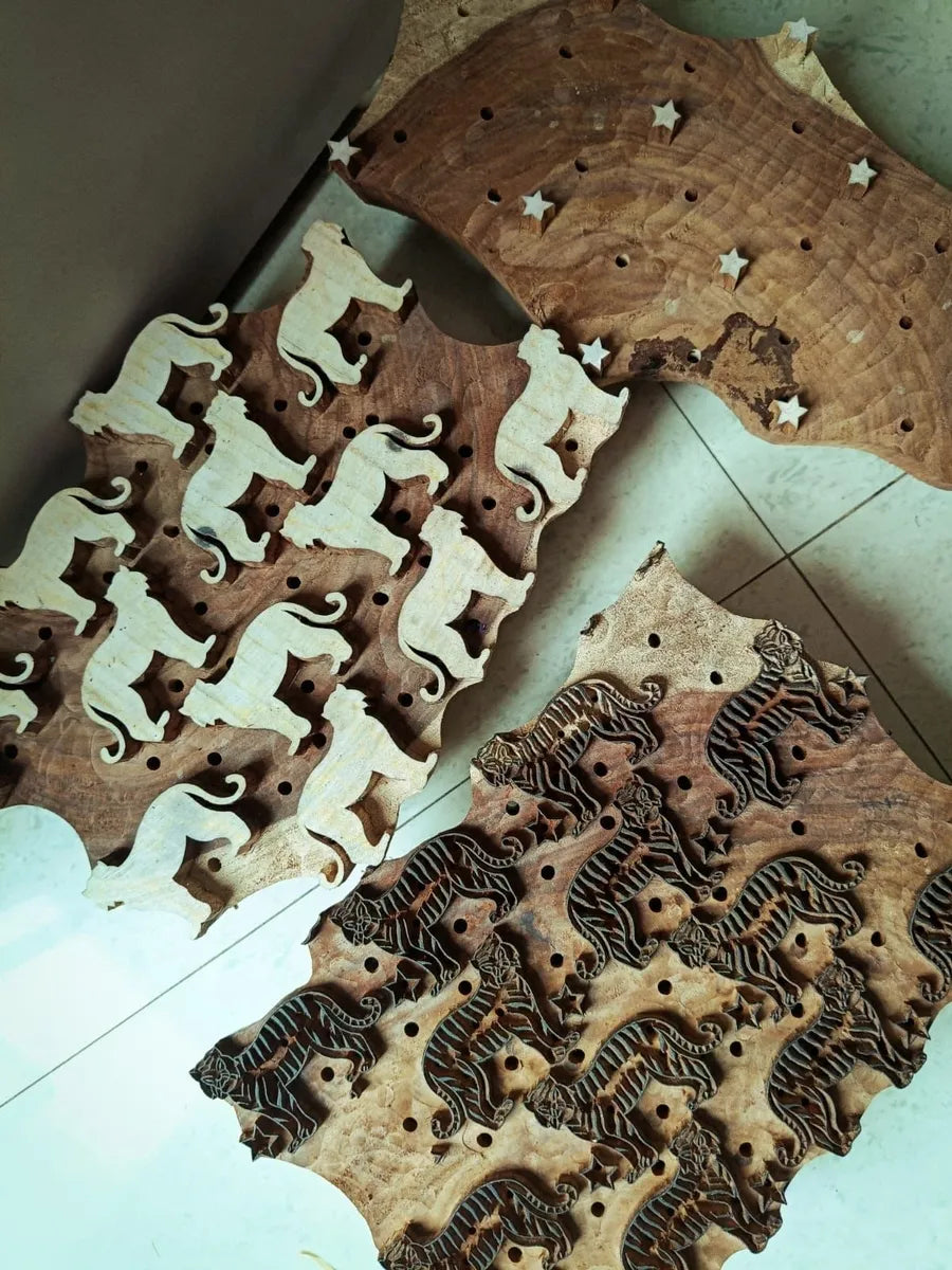 Wooden puzzle pieces with star patterns on a tiled floor.
