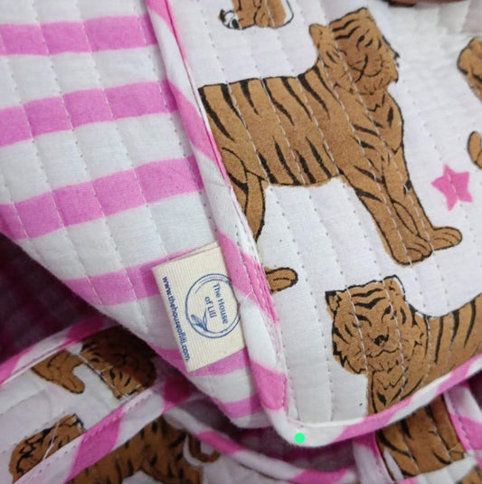 Baby blanket with tiger pattern and pink checkered border, featuring a visible brand label.