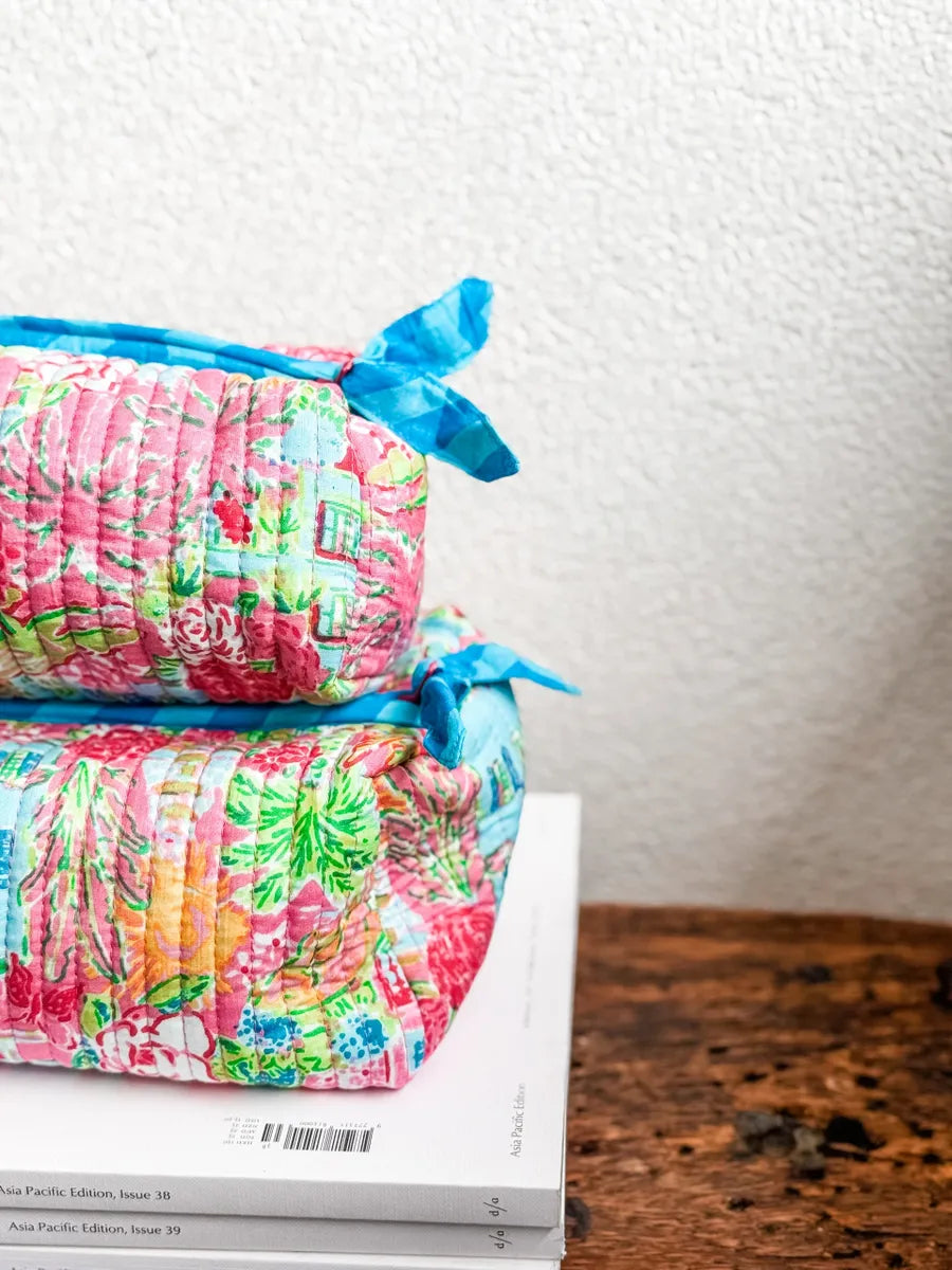 Two folded items with colorful patterns and blue ribbons on a white surface.