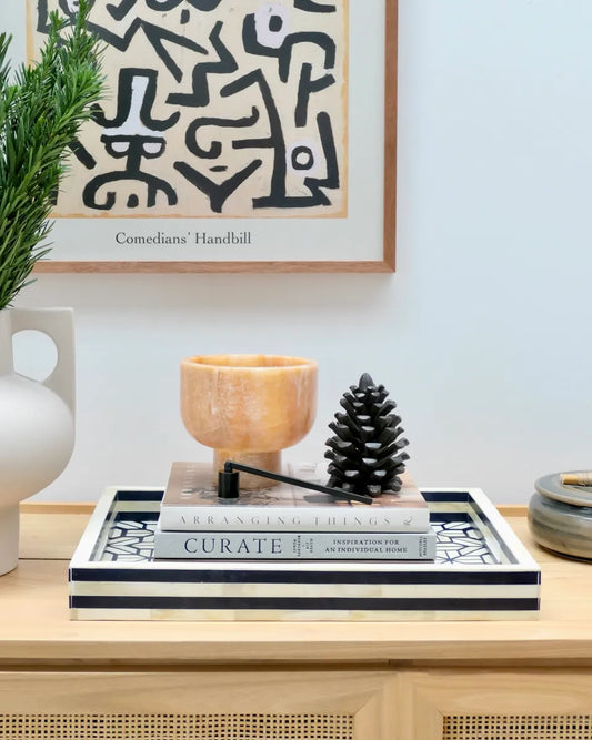 Decorative items on a table with a framed artwork in the background