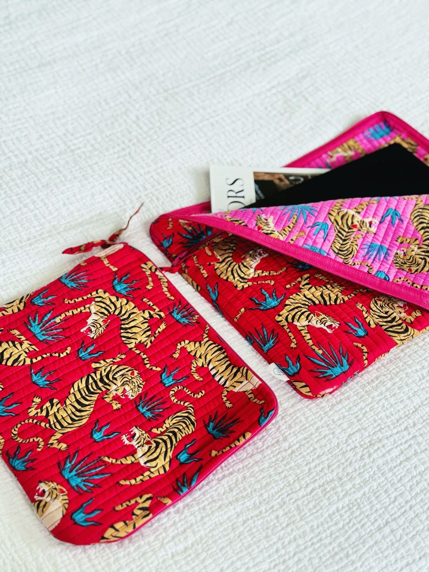 Two red pouches with tiger pattern on a white surface