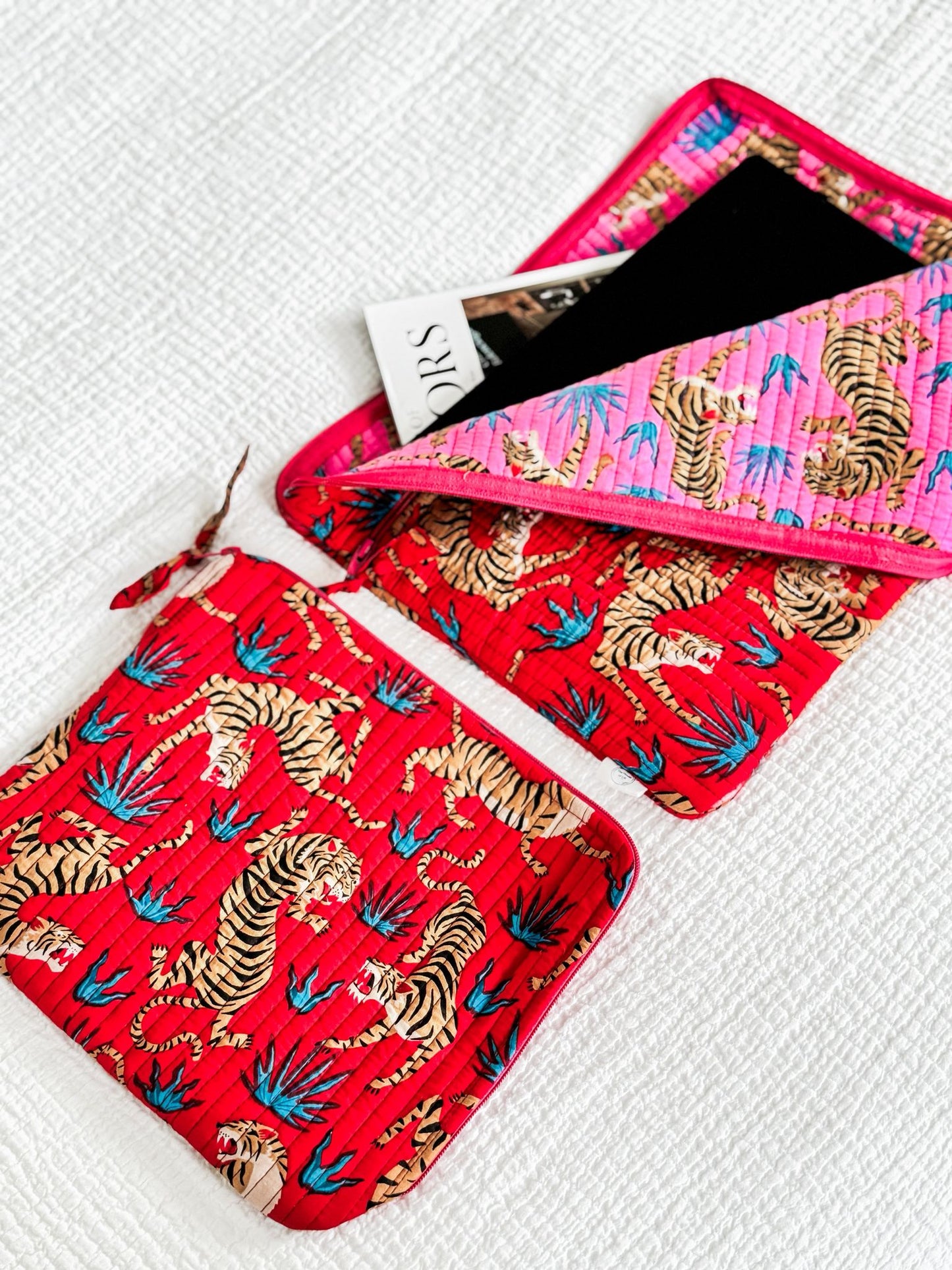 Two fabric pouches with tiger and palm tree pattern on a white background