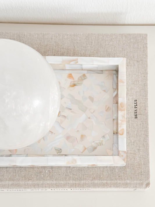Decorative tray with marble-like surface and beige frame on a white background
