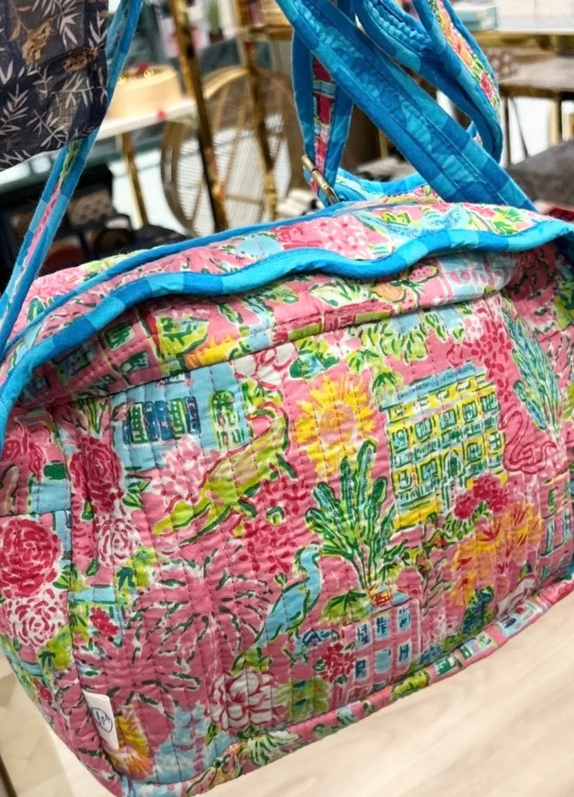 Colorful patterned bag with blue trim on a blurred indoor background