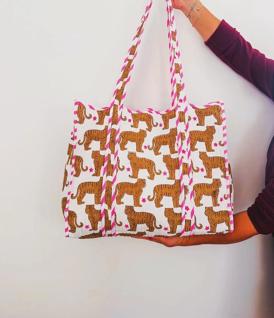 Tote bag with tiger pattern held by a person against a white background