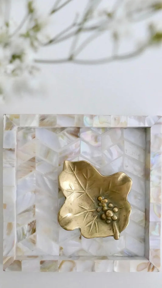 Decorative tray with a gold leaf design on a marble-patterned background