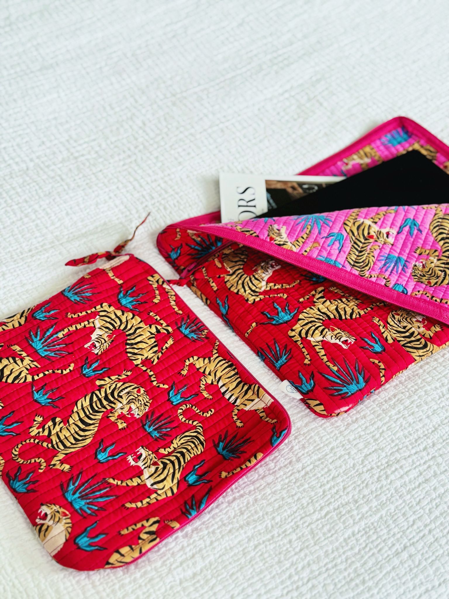 Two red pouches with tiger pattern on a white surface