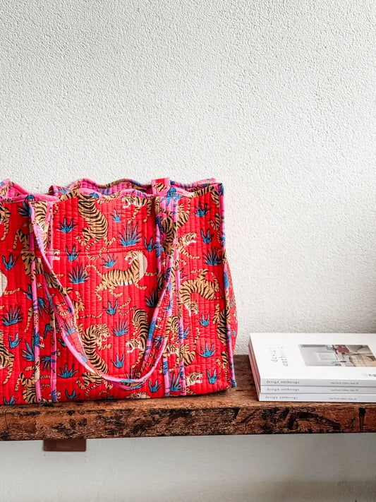 Red patterned bag on a wooden surface with a white background
