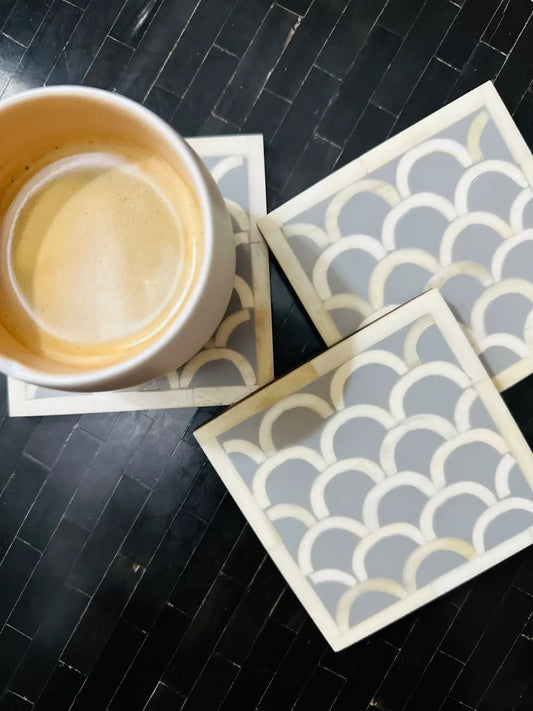 Patterned coasters with a cup of coffee on a dark surface